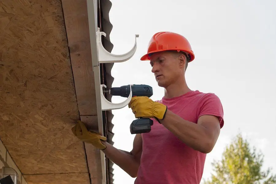Repair work at a gutter and downspout connection